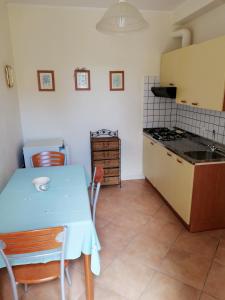 una cucina con tavolo blu e piano cottura forno superiore di La Ginestra a Sirolo