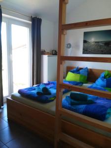 a bedroom with two bunk beds with blue pillows at Piratennest- Kojen in Dranske