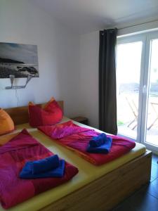 a bedroom with two beds with colorful pillows on them at Piratennest- Kojen in Dranske