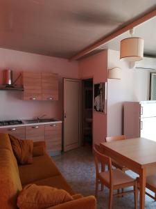 Il comprend un salon et une cuisine avec un canapé et une table. dans l'établissement Villa Itaca, à Sant'Isidoro