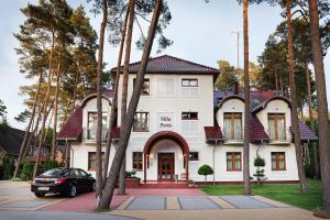 a house with a car parked in front of it at Villa Porto in Pobierowo
