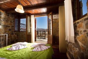 a bedroom with a green bed and a balcony at Monastiraki Traditional Guest House in Monastirákion