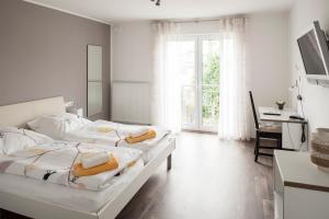 a white bedroom with two beds and a desk at Schwanenhof Hotel und Restaurant in Erkelenz