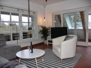 a living room with a couch and a chair and a table at Ferienwohnung An der Farchauer Mühle in Schmilau