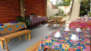 a patio with two tables and chairs and tables with plates and cups at Pousada Maia in Itaúnas +15 photos