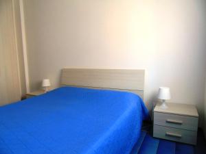 1 dormitorio con 1 cama azul y 2 mesitas de noche en Deiva Holidays, en Deiva Marina