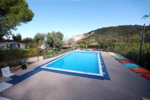 a swimming pool in a yard with a mountain at Acquaviva Village Camping in Portoferraio