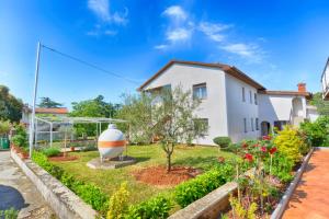 a house with a garden in front of it at Apartment & room Milka 1633 in Pula