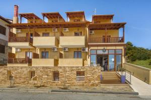 un gran edificio amarillo con balcones. en Ouranoupolis Princess, en Ouranoupoli