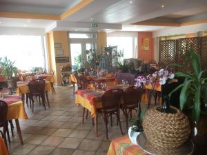 a restaurant with tables and chairs in a room at Hôtel aux Bruyères in Orbey