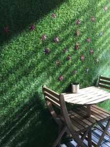 a table and a chair next to a wall with flowers at Faloe Hostel in Kota Kinabalu