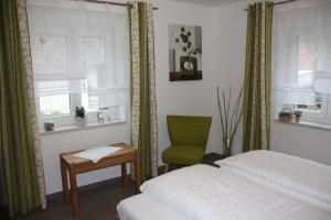 a bedroom with two beds and a green chair at Ferienwohnungen Christine in Bad Staffelstein +53 photos