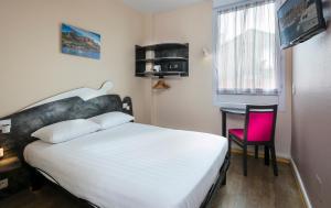 a bedroom with a white bed and a pink chair at L'Esterel in Cannes