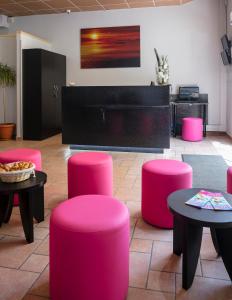 a room with pink stools and tables and a piano at L'Esterel in Cannes