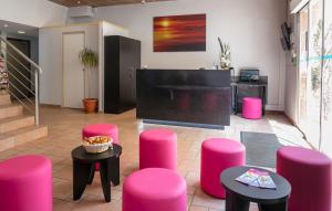 a lobby with pink stools and a stage in a room at L'Esterel in Cannes