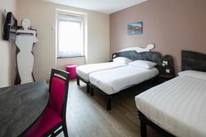 a hotel room with two beds and a table and chairs at L'Esterel in Cannes