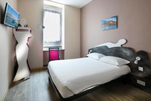 a bedroom with a bed and a flat screen tv at L'Esterel in Cannes