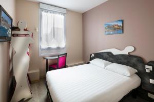 a bedroom with a white bed and a window at L'Esterel in Cannes