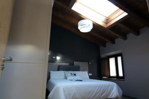 1 dormitorio con cama blanca y tragaluz en Gaubeako Ekhia en Espejo