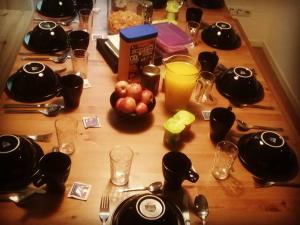 a wooden table with utensils and glasses on it at The Nook Hostel in Ponta Delgada