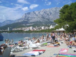 una multitud de personas en una playa con una montaña en Apartment Mikula, en Makarska