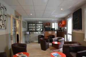 a living room with couches and tables and a kitchen at Hôtel Restaurant Le Martagon in Villars-Colmars