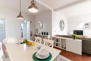 a kitchen and living room with a white table and chairs at Quinta Deão I by An Island Apart in Funchal