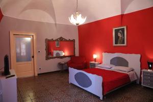 Dormitorio rojo con cama y espejo en la locanda del centro storico, en Catania