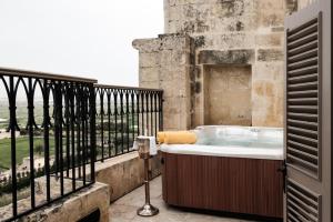 a bath tub on the balcony of a building at The Xara Palace Relais & Chateaux in Mdina