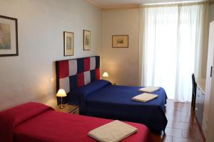 una camera d'albergo con due letti e una finestra di L'elefante a Catania
