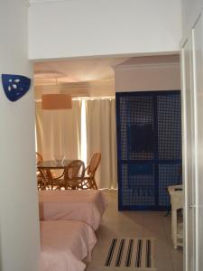 塔維拉的住宿－Estudio Piscina e Praia, Cabanas de Tavira，一间设有两张床和一张桌子及椅子的房间