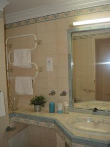a bathroom with a sink and a mirror at Estudio Piscina e Praia, Cabanas de Tavira in Tavira