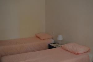 塔維拉的住宿－Estudio Piscina e Praia, Cabanas de Tavira，客房设有两张床和一张带台灯的桌子。