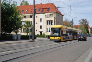 un autobús amarillo conduciendo por una calle de la ciudad en Dresdner Ferien Apartment, en Dresden