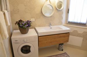 een badkamer met een wasmachine en een wastafel bij Home Balloon in Santa Maria Navarrese