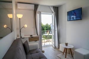 uma sala de estar com um sofá e uma porta de vidro deslizante em Apartments Sunset em Hvar