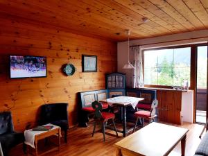 una sala de estar con mesa y sillas en una cabaña en Tyrol Appartements, en Ehrwald