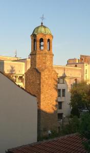 a brick building with a bell tower on top of it at Family Hotel Rositsa in Sevlievo