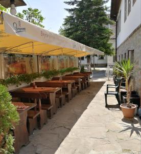 a patio area with tables, chairs and umbrellas at Family Hotel Rositsa in Sevlievo