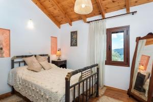1 dormitorio con cama y ventana en Samarian Cottage, en Lákkoi