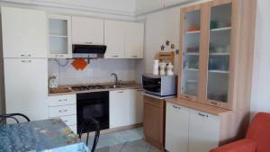 a small kitchen with white cabinets and a microwave at Casa Relax in Villasimius +13 photos