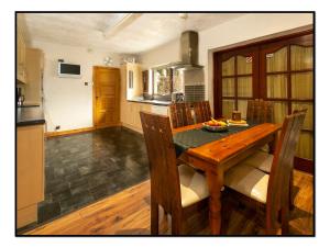 a kitchen and dining room with a wooden table and chairs at Burndavis Lodge in Ballymena