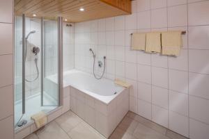 a white bathroom with a shower and a sink at Hotel Gasthof Post in Nesselwang +74 photos