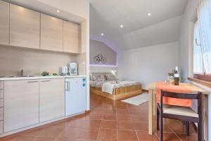 a kitchen with a table and a bed in a room at Studio Mia in Premantura