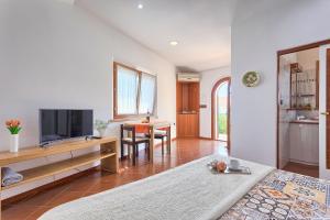 a room with a bed and a table with a television at Studio Mia in Premantura
