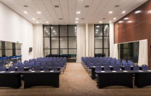 a conference room with blue chairs and a stage at Transamerica Executive Taboao Morumbi in Taboão da Serra
