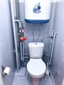 a bathroom with a toilet and a water tank at Apartments Plaza in Krasnoyarsk