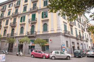 un grande edificio con macchine parcheggiate di fronte di 319 al Duomo a Napoli