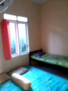 Giường trong phòng chung tại Kenangan Guest House