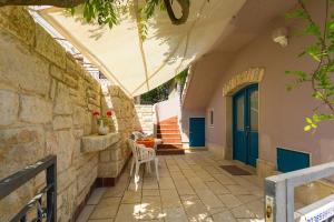 a patio with a blue door and a stone wall at Studio Mia in Premantura